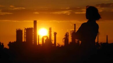 woman looking at factory on sunset