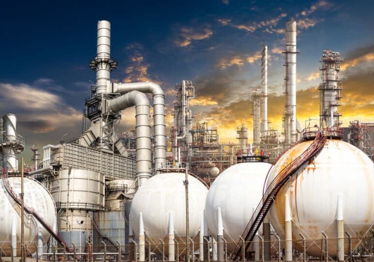 Structure of the oil refinery building on sunset background